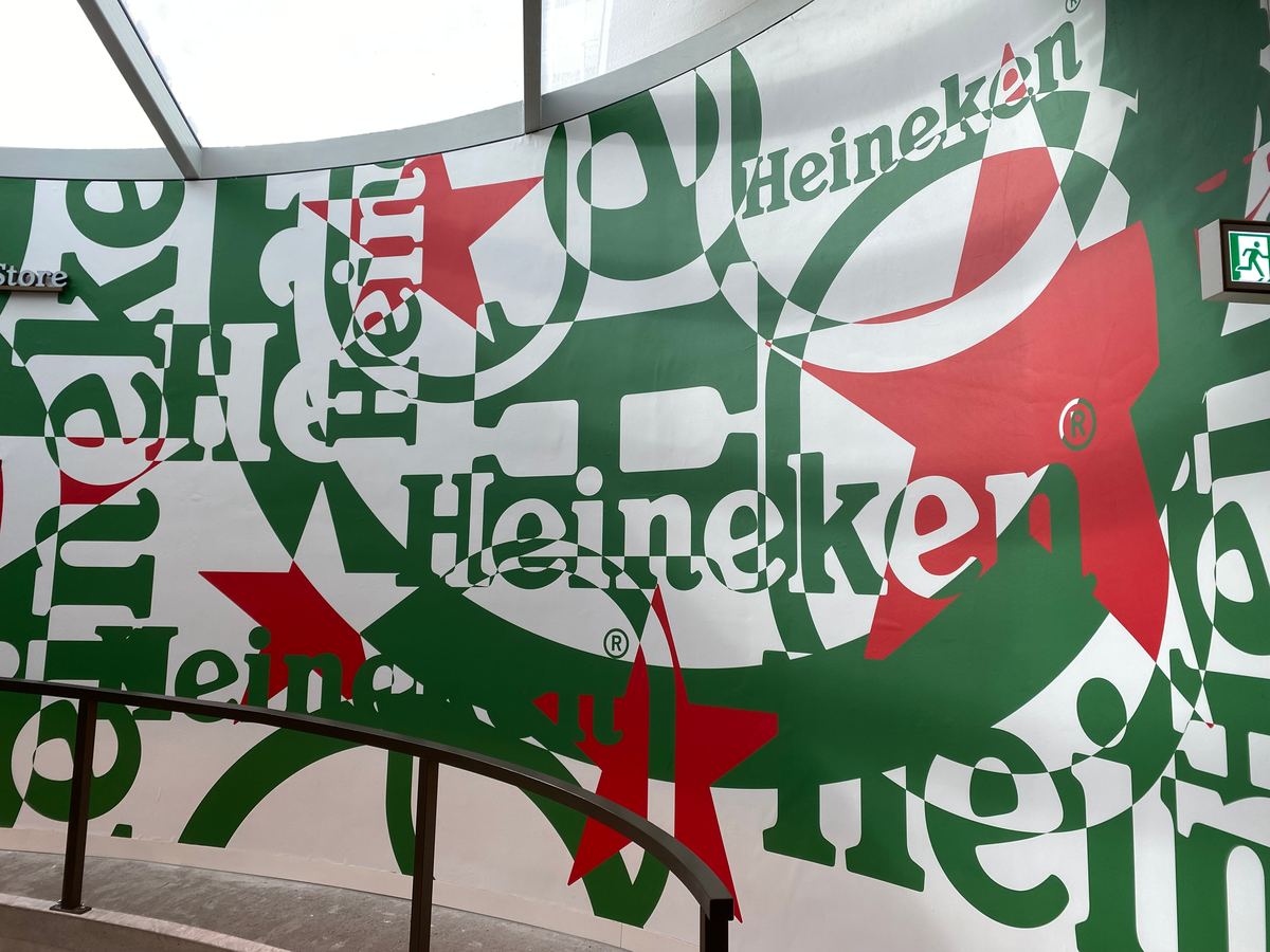 De Heineken-muur, vol in elkaar geschoven logo's in groen, rood en wit