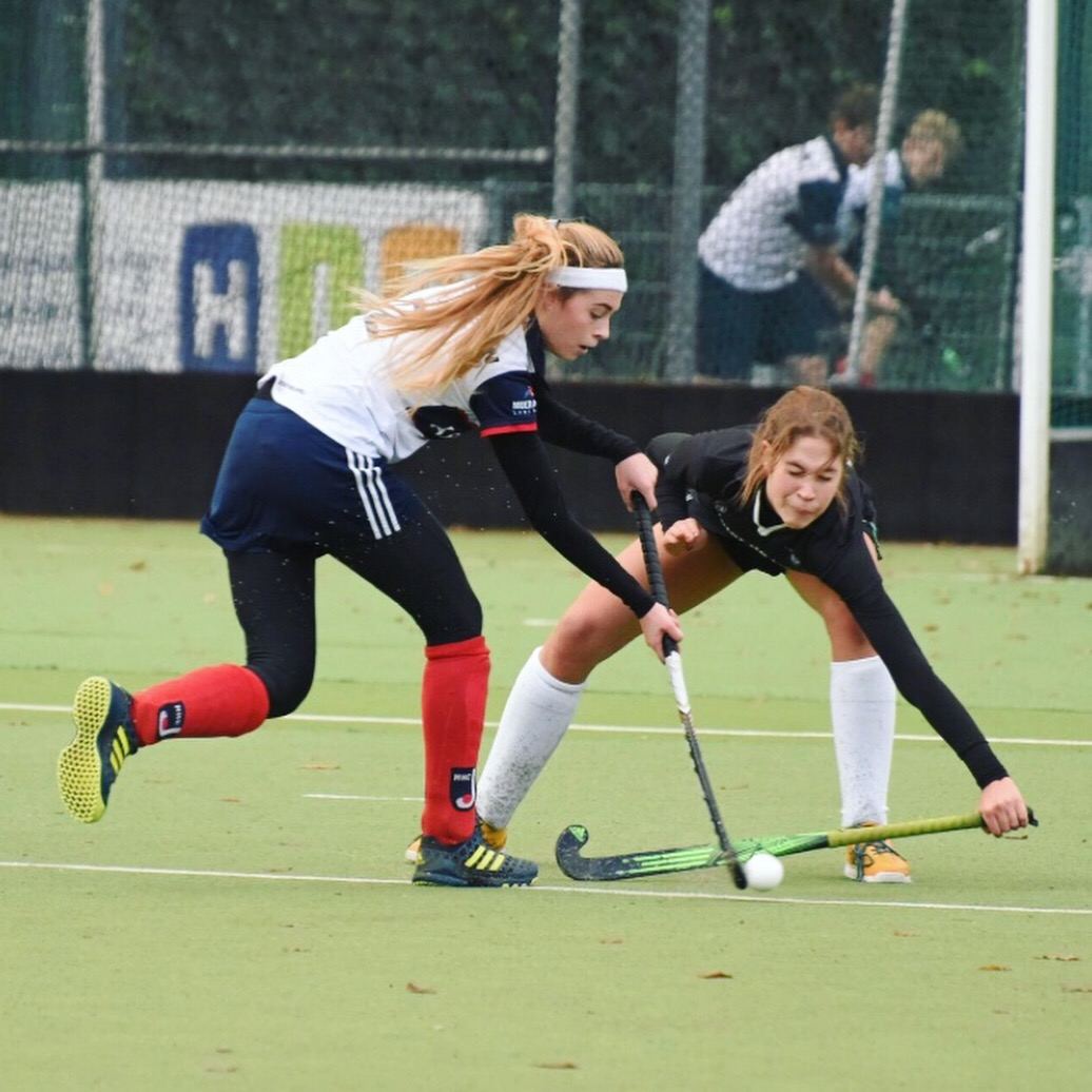 Eva in een duel om de bal op het hockeyveld